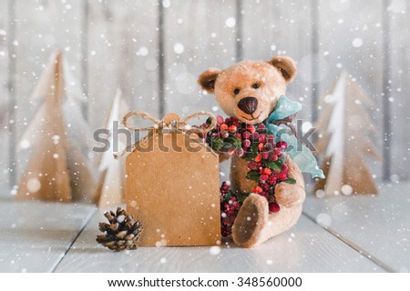Teddy Bear with a blank for congratulations on a wooden background