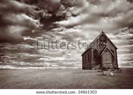 Abandoned church in the desert, with stormy skies.  Monotone image, with added grain. Royalty-Free Stock Photo #34861303