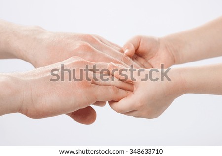Hands of child father holding together tenderly, closeup shot