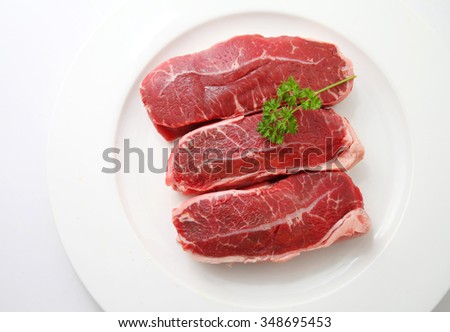 Fresh raw beef lamb fillet on the white plate Royalty-Free Stock Photo #348695453