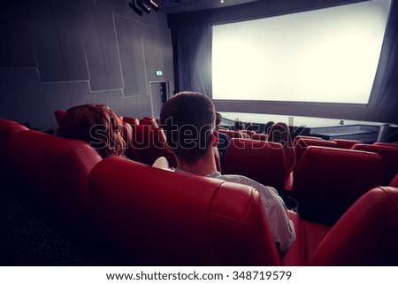 cinema, entertainment, leisure and people concept - couple watching movie in theater from back Royalty-Free Stock Photo #348719579
