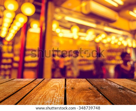 image of blurred night market decorated with festive lights for background usage . (vintage tone)
