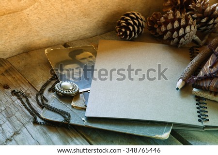 open notebook and antique photos on wooden table. retro filtered and toned image 