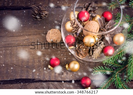 Christmas toys, nuts, fir cones and twigs on a wooden background. Top view, Meslin for text, toning, snow