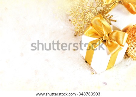 Gift box with golden ribbon and light christmas background. Card or invitation.