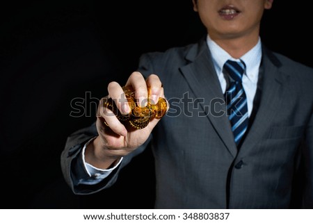 Businessman holding gold coins isolated on black