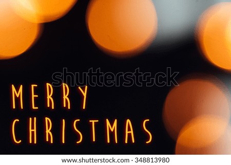 amazing blurred christmas golden  lights on stylish black background, merry christmas text