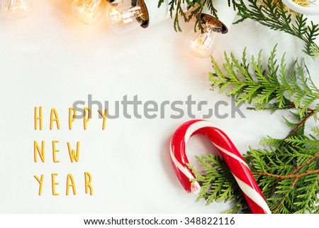 green branches and amazing christmas golden vintage garland  and candy on white background, happy new year text