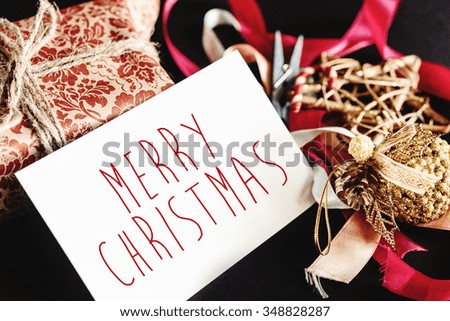 beautiful gorgeous present in design paper with ribbons, toys and card, merry christmas text