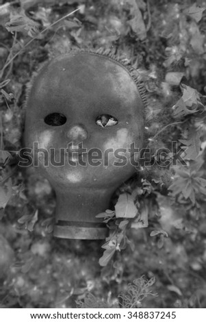 Voodoo Doll. Close up of scary dirty old retro vintage aged used puppet face lie on summer land between grass.