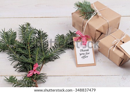 Business Marketing Ideas for Christmas Client Gifts. Christmas and New Year vintage gift boxes with Thank you for offer tag on white background. New year presents and fir branch on white rustic table