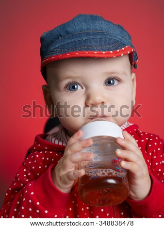 photo of little girl drinking juice from bottle