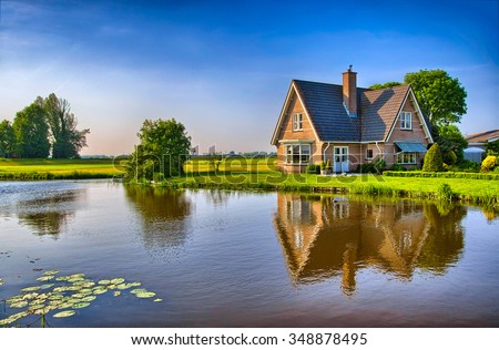 Red bricks house in countryside near the lake with mirror reflection in water, Amsterdam, Holland, Netherlands, HDR Royalty-Free Stock Photo #348878495