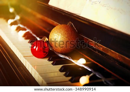 Piano keys decorated with decorative lights and balls, close up