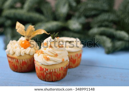 choice of three cupcakes on a blue wooden background