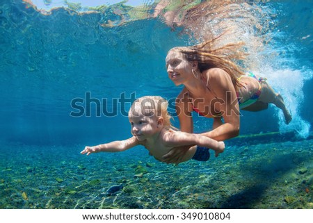 Happy family - mother with baby boy dive underwater with fun in sea pool. Healthy lifestyle, active parent, people water sport outdoor activity and swimming lessons on beach summer holidays with child