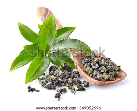 Fresh green tea leaves with wooden spoon