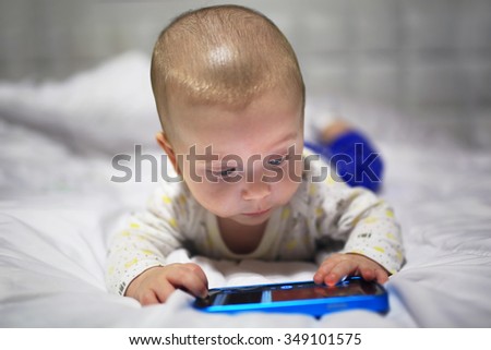 Baby boy watching movie on the mobile phone