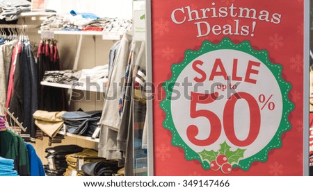 Sale promotion notice for Christmas deals in the front of a clothes store at shopping mall. Panoramic style