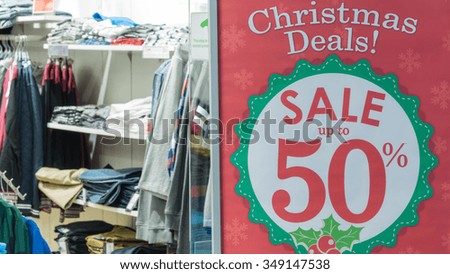 Sale promotion notice for Christmas deals in the front of a clothes store at shopping mall. Panoramic style