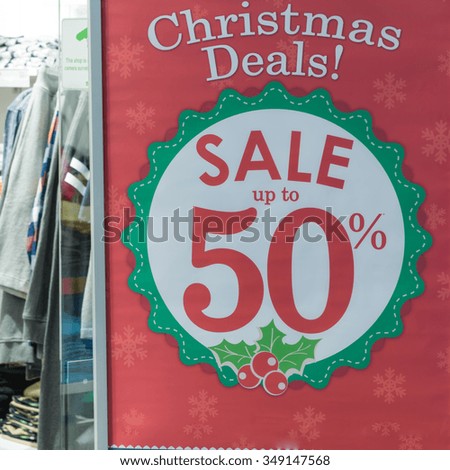 Sale promotion notice for Christmas deals in the front of a clothes store at shopping mall