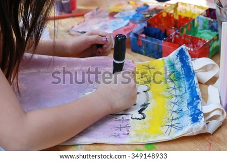 asian girl use brush paint picture on fabric bag ,Little girl and boy painting picture by brush on table in kindergarten, artist tool and imagination ,art school.
