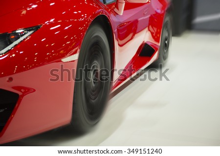 Front of red car wheel with heavy blurred motion.
