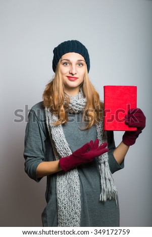 blonde girl with the book in hand, the concept of Christmas and New Year, studio photo isolated on a gray background