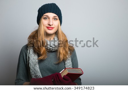 blonde girl with the book in hand, the concept of Christmas and New Year, studio photo isolated on a gray background
