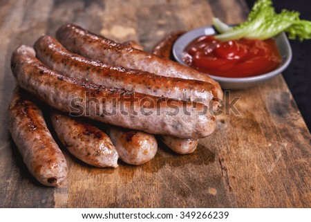 roasted sausages and ketchup on wooden table Royalty-Free Stock Photo #349266239