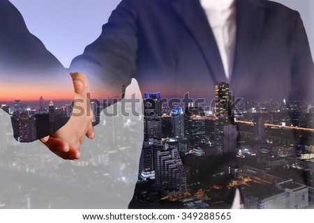 Double exposure of business handshake and night city as commitment, economy, partnership and investment concept. Royalty-Free Stock Photo #349288565
