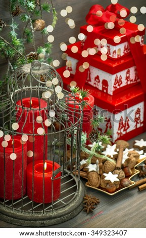 Christmas decorations, gift box, red candles, cookies, nuts and spices. Vintage style toned picture with lights