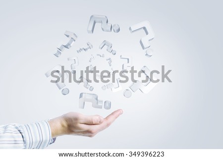 Close up of businessman hand holding glass question symbols 