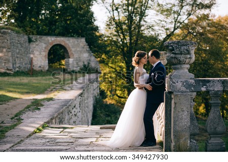 Bride and groom at wedding Day walking Outdoors on castle territory. Bridal couple, Newlywed woman and man embracing with love Royalty-Free Stock Photo #349427930
