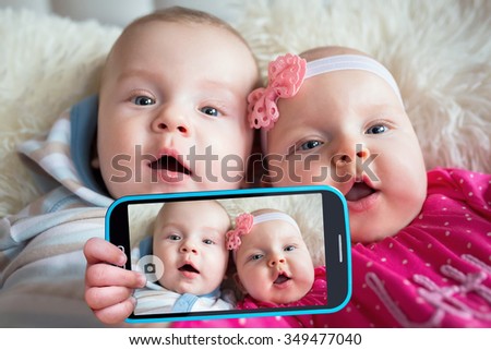 Twins taking selfie with a cell phone camera