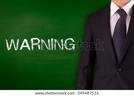 WARNING on Blackboard with businessman