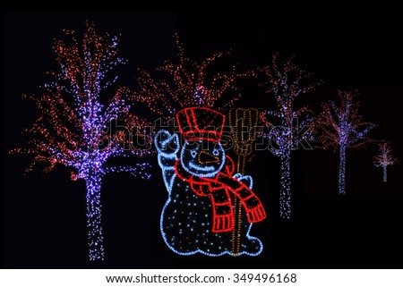Outdoor night shot of Illuminated trees and Snowman for the perfect Christmas atmosphere