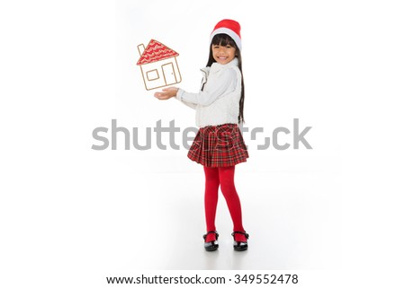 little asian girl holding a drawn house and smiling isolated on white background