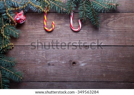 Christmas tree branch and candy cane on a wooden table or board for background. New year theme. Space for text.
