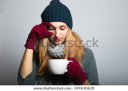blond girl drinking tea or coffee in the morning to wake up Christmas concept studio photo isolated on a gray background