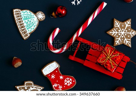 Sledge with gift, Christmas cookies, candy on a dark background. Christmas pattern.