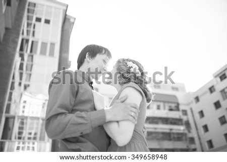 Couple in love kissing laughing having fun. Dating interracial young couple embracing on date. Pretty spring sunny outdoor portrait of young stylish couple while kissing on the street. Relationships