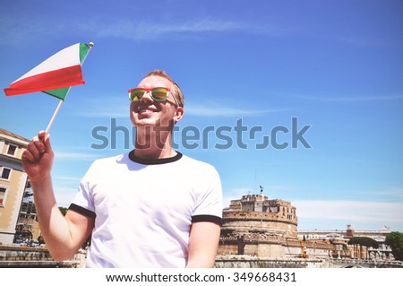 Young happy tourist with Italian flag in Rome - toned picture