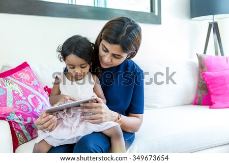 Happy mother and daughter play tablet together
