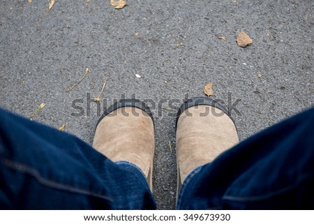 brown suede shoes standing on the asphalt concrete floor