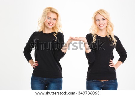 Portrait of a happy sisters twins holding copyspace on the palms isolated on a white background