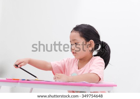 Asian little girl holding color pencil on white background