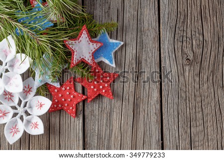 Christmas colored felt decoration on rough wooden background