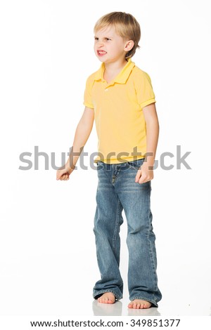 Beautiful blond boy in a yellow T-shirt angry. Isolated on white background. Shooting in the studio