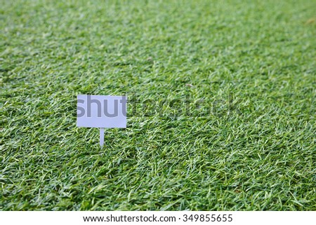 Sign on grass, green lawn, with space for caption, dreamy color
